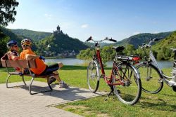 Cyclists seated on a bench next to bikes