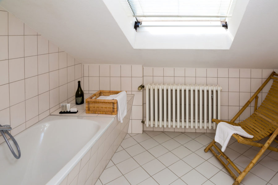 Hotel bathroom with bathtub and deckchair