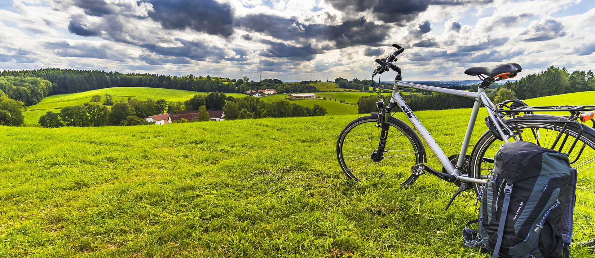 Backpack next to a bicycle on a grass field