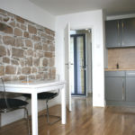 Kitchen with stove, cupboard, chairs, and table