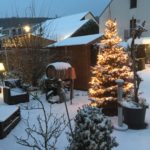 Christmas tree and outside seating area covered with snow